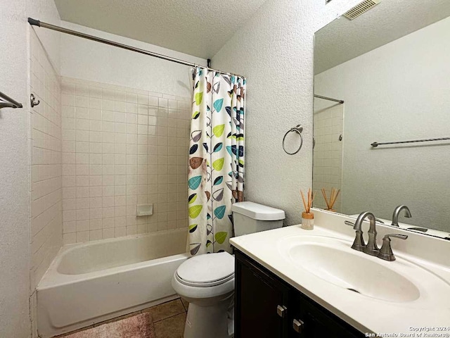 full bathroom featuring vanity, a textured ceiling, shower / bath combo with shower curtain, tile patterned floors, and toilet