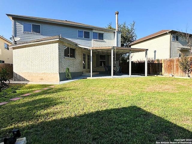 back of house featuring a lawn and a patio area