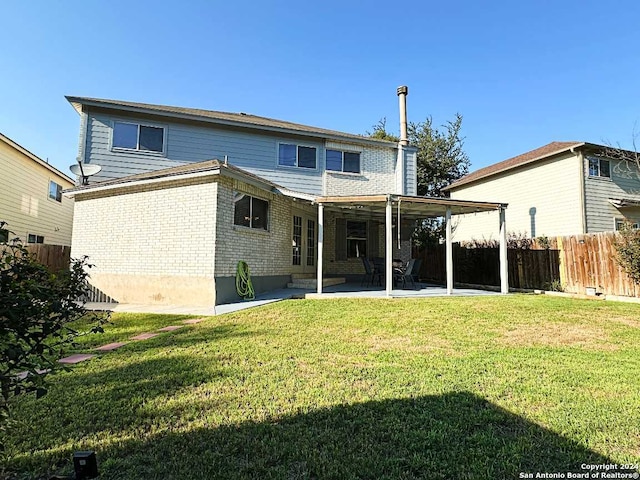 rear view of house featuring a yard and a patio area