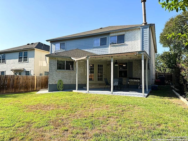 back of property featuring a lawn and a patio