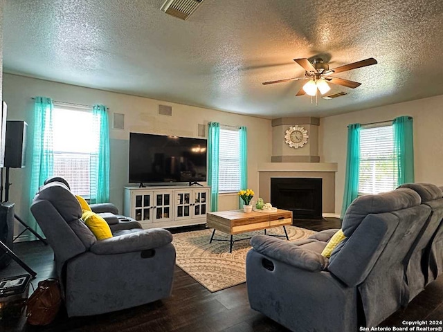 living room featuring ceiling fan, a textured ceiling, and plenty of natural light