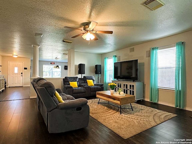 living room featuring dark wood-type flooring, ceiling fan, a healthy amount of sunlight, and a textured ceiling