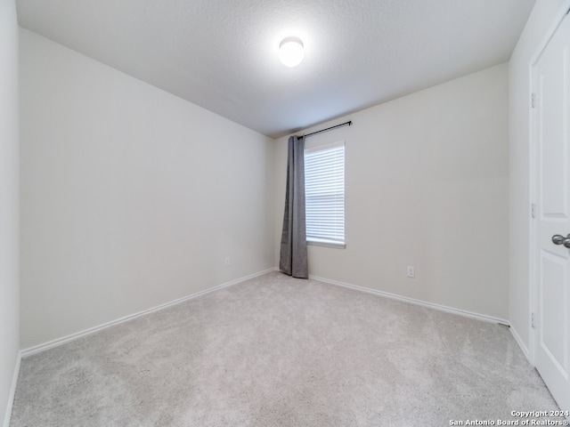 carpeted spare room featuring a textured ceiling