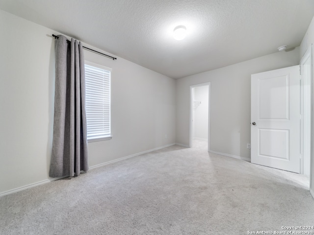 carpeted spare room featuring a textured ceiling