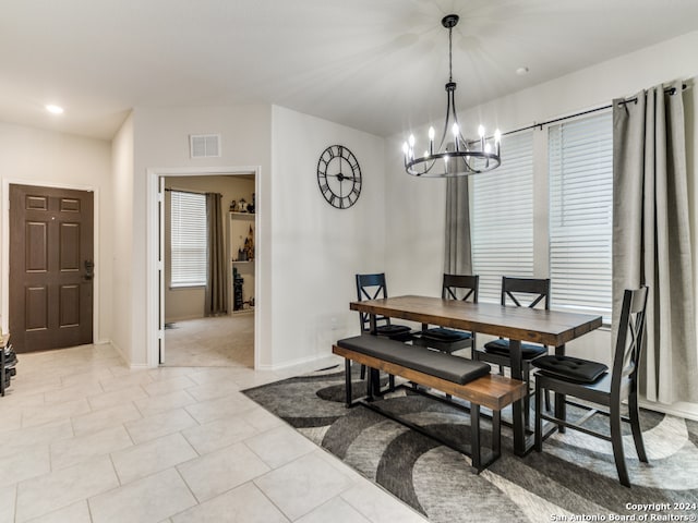 tiled dining area with an inviting chandelier