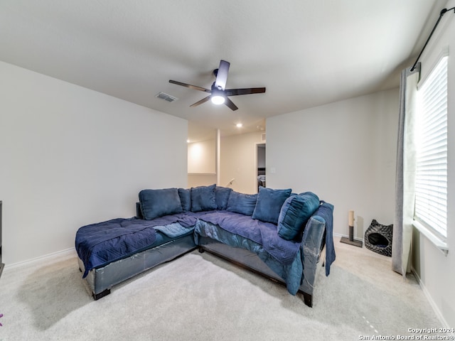 carpeted living room with ceiling fan and plenty of natural light