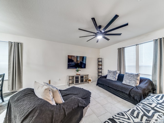 living room with ceiling fan and light tile patterned flooring