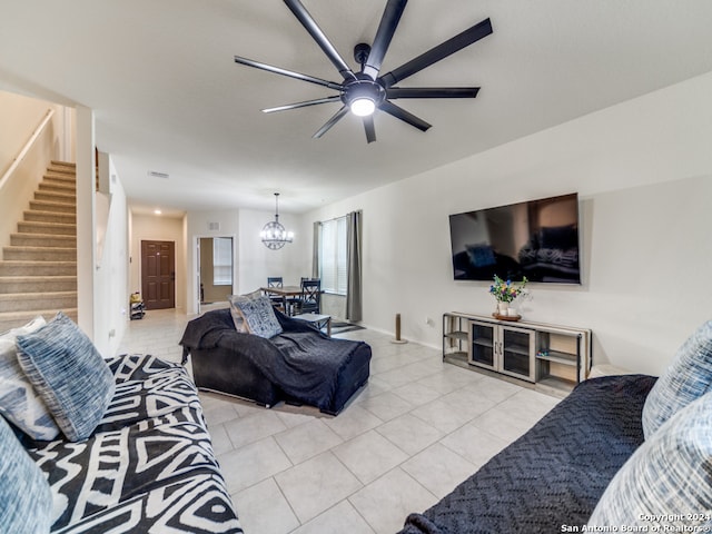 living room featuring ceiling fan with notable chandelier and light tile patterned floors