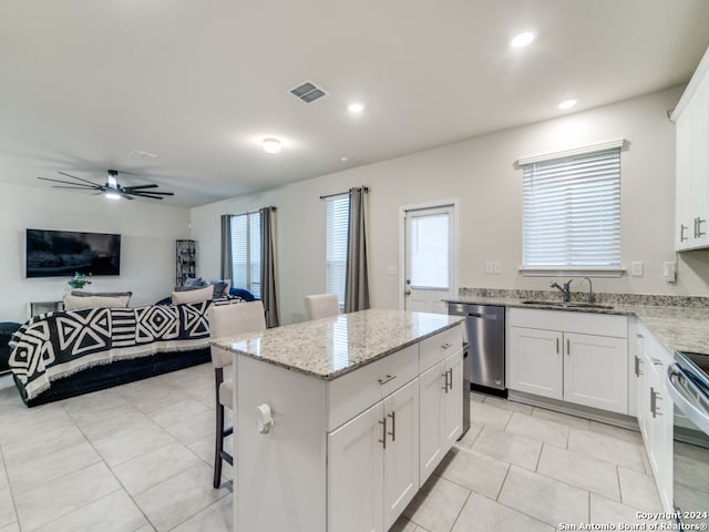 kitchen featuring a center island, sink, white cabinets, appliances with stainless steel finishes, and ceiling fan