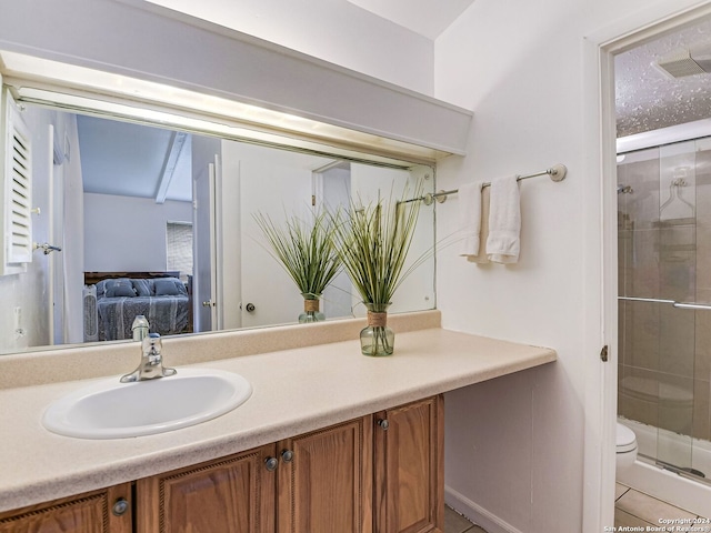 bathroom featuring vanity, a shower with shower door, and toilet