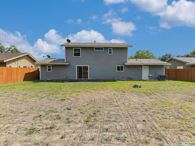 rear view of property featuring central air condition unit and a yard