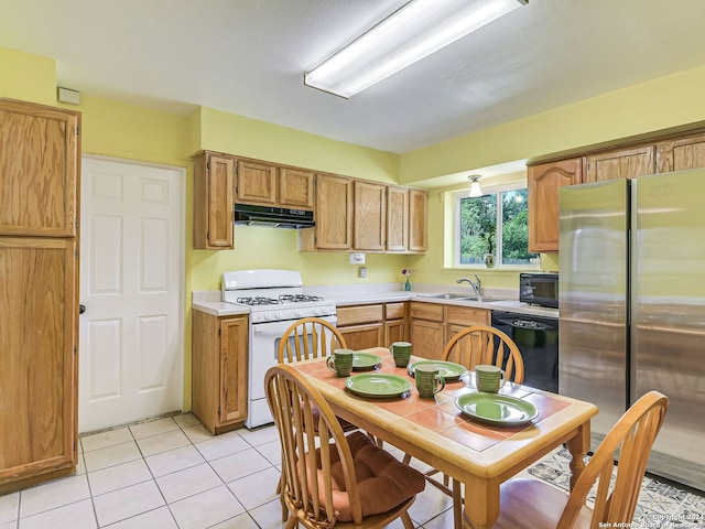 kitchen with black appliances, light tile patterned flooring, and sink