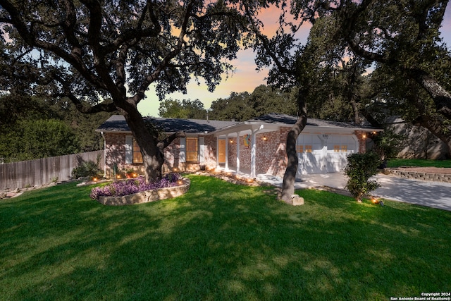 ranch-style house featuring a lawn and a garage