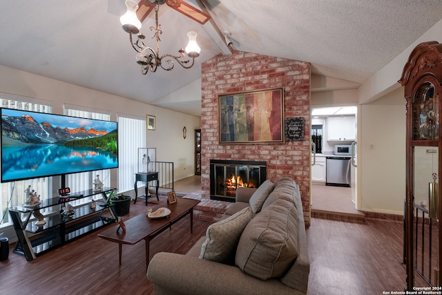 living room featuring vaulted ceiling with beams, a brick fireplace, a textured ceiling, hardwood / wood-style flooring, and a notable chandelier