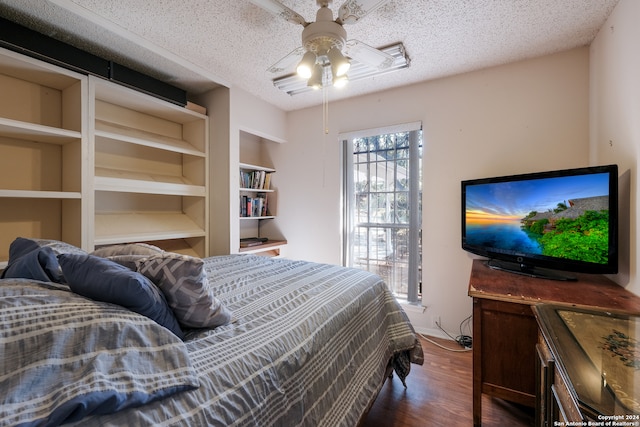 bedroom with a textured ceiling, dark hardwood / wood-style floors, and ceiling fan