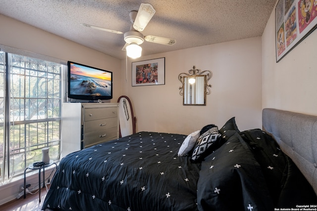 bedroom featuring a textured ceiling, wood-type flooring, and ceiling fan