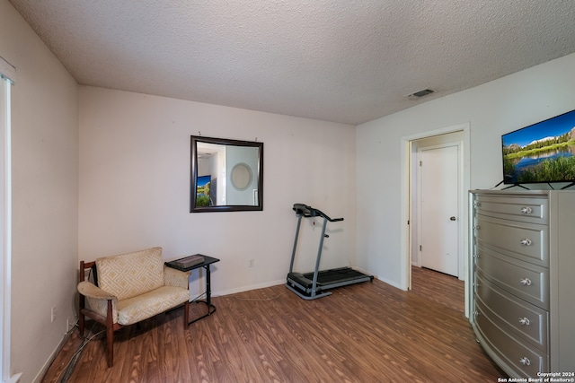 living area with a textured ceiling and dark hardwood / wood-style floors