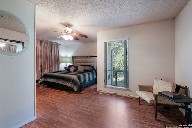 bedroom with wood-type flooring, ceiling fan, and a textured ceiling