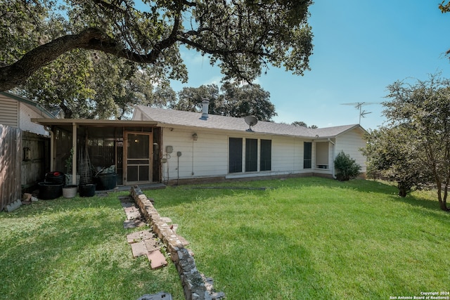 back of house with a lawn and a sunroom