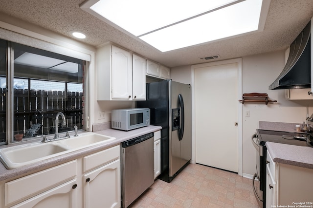 kitchen with appliances with stainless steel finishes, white cabinetry, sink, and range hood