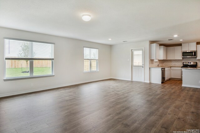 unfurnished living room featuring hardwood / wood-style floors and a wealth of natural light