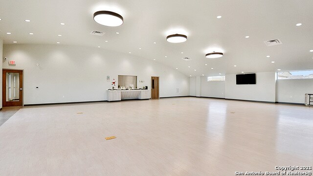 unfurnished room featuring vaulted ceiling and light hardwood / wood-style floors