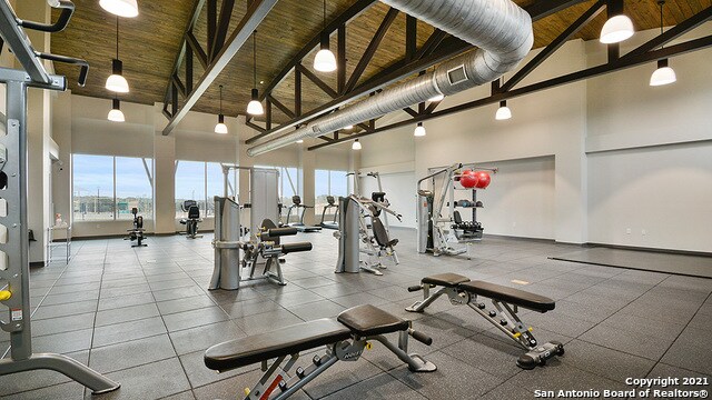 exercise room featuring wood ceiling and high vaulted ceiling