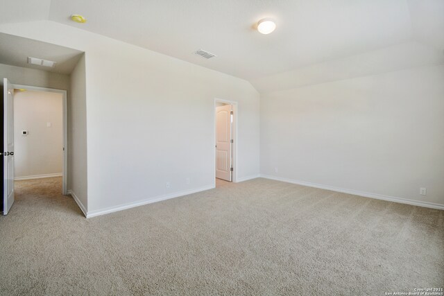 carpeted empty room featuring lofted ceiling