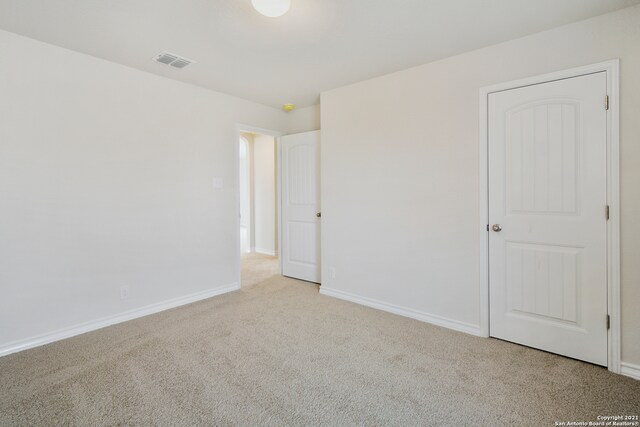 unfurnished bedroom featuring light carpet