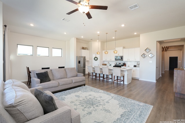 living room featuring dark hardwood / wood-style flooring and ceiling fan