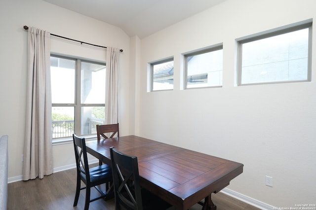 dining room featuring vaulted ceiling, dark hardwood / wood-style floors, and plenty of natural light