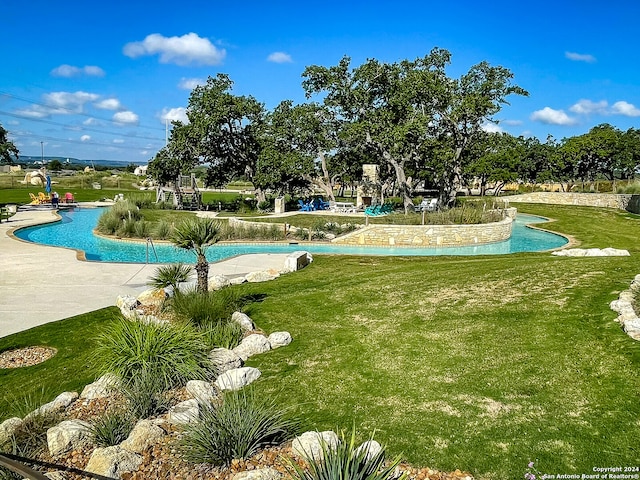 view of swimming pool with a yard