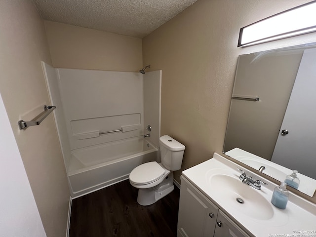 full bathroom with wood-type flooring, bathing tub / shower combination, toilet, a textured ceiling, and vanity