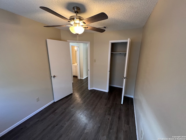 unfurnished bedroom with a textured ceiling, dark hardwood / wood-style floors, a closet, and ceiling fan