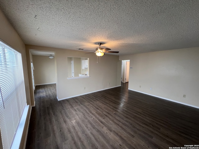 empty room with dark wood-type flooring, a textured ceiling, and ceiling fan