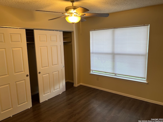 unfurnished bedroom featuring a closet, ceiling fan, dark hardwood / wood-style floors, and a textured ceiling