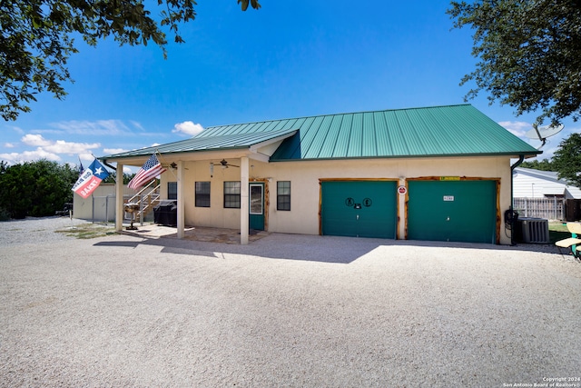 view of front of home with ceiling fan, central AC unit, a carport, and a garage