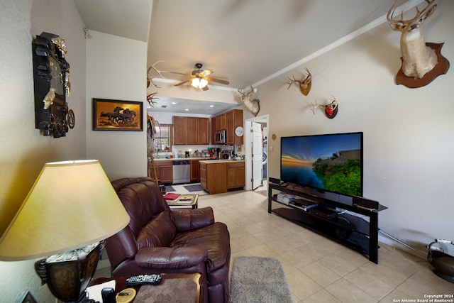 living room with crown molding, light tile patterned flooring, and ceiling fan