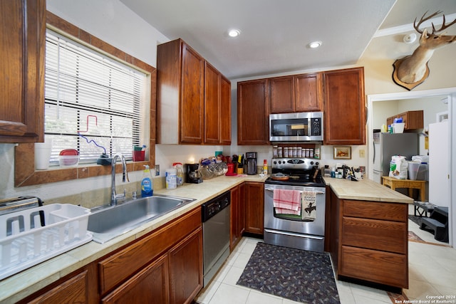 kitchen featuring light tile patterned floors, appliances with stainless steel finishes, and sink