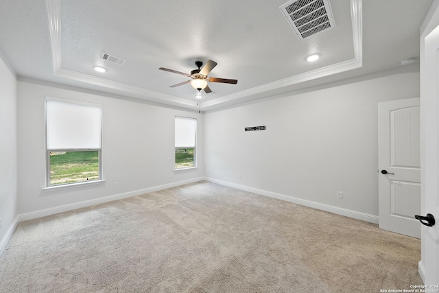 carpeted spare room with ornamental molding, ceiling fan, a raised ceiling, and a textured ceiling