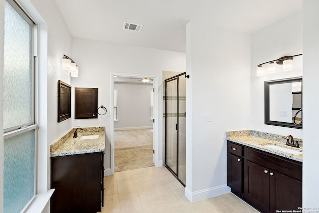 bathroom featuring tile patterned flooring, vanity, ceiling fan, and a shower with door