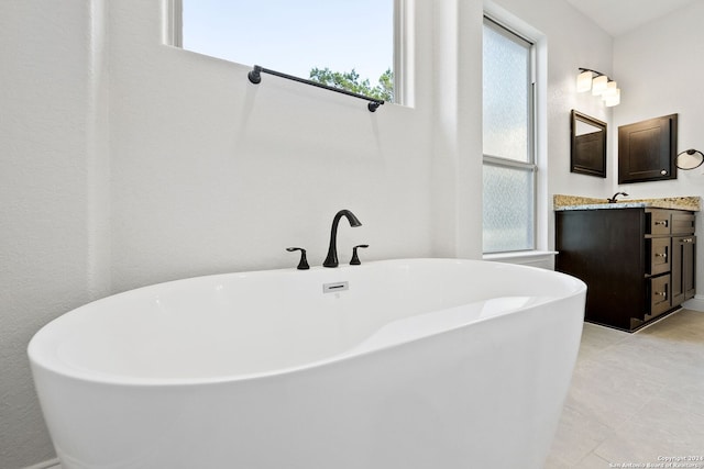 bathroom with vanity, a bathing tub, and tile patterned flooring