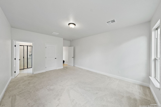 unfurnished bedroom with multiple windows and light colored carpet