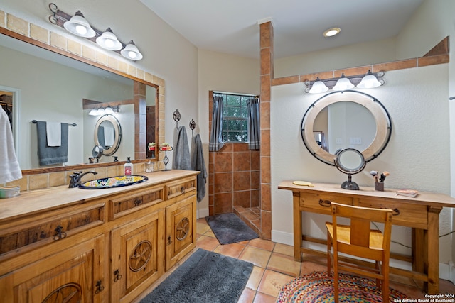 bathroom featuring a tile shower, tile patterned flooring, and vanity