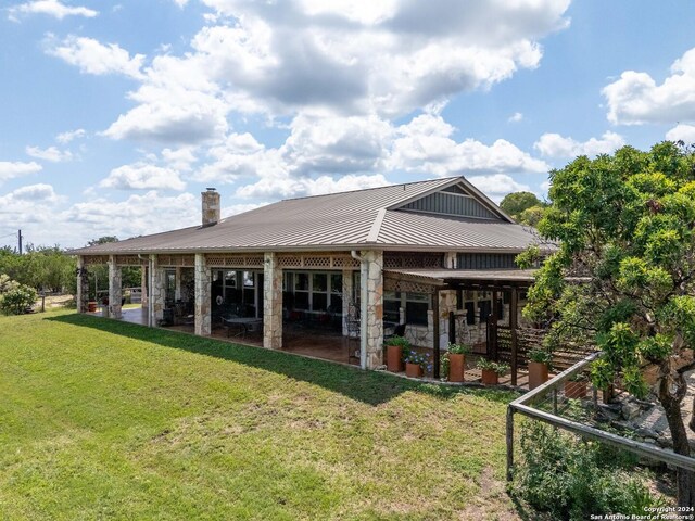 rear view of house featuring a lawn and a patio area