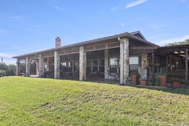 rear view of property featuring a yard