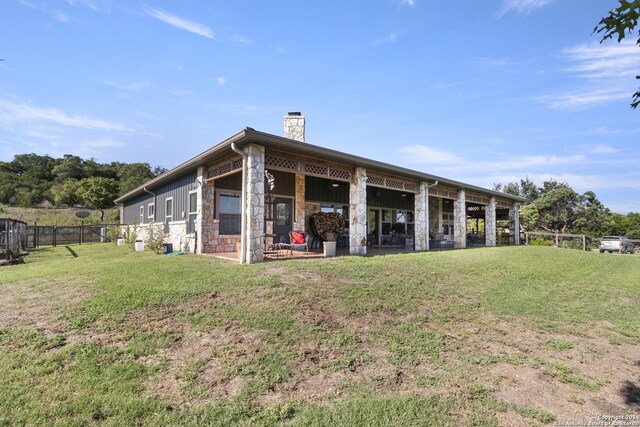 back of property featuring a lawn