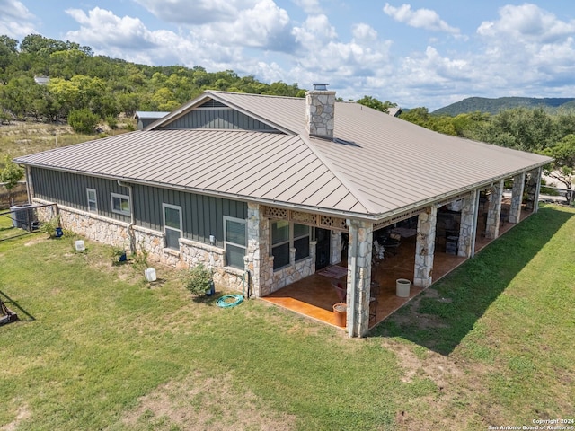 back of property with a yard and a patio area