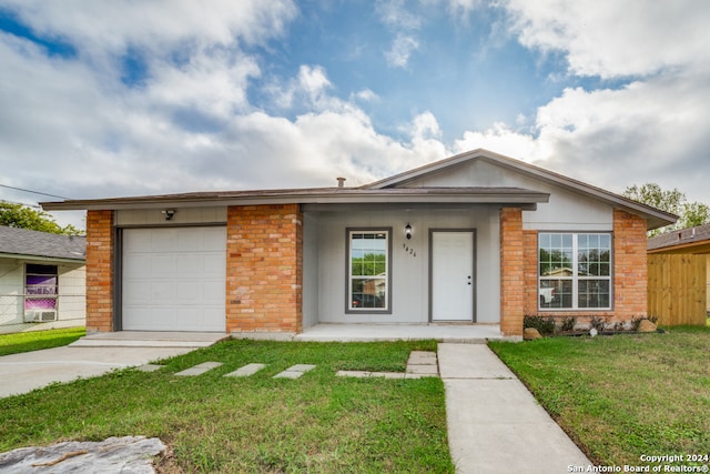 single story home featuring a porch, a garage, and a front lawn