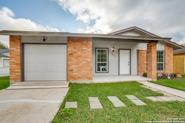 ranch-style home with a garage, covered porch, and a front yard